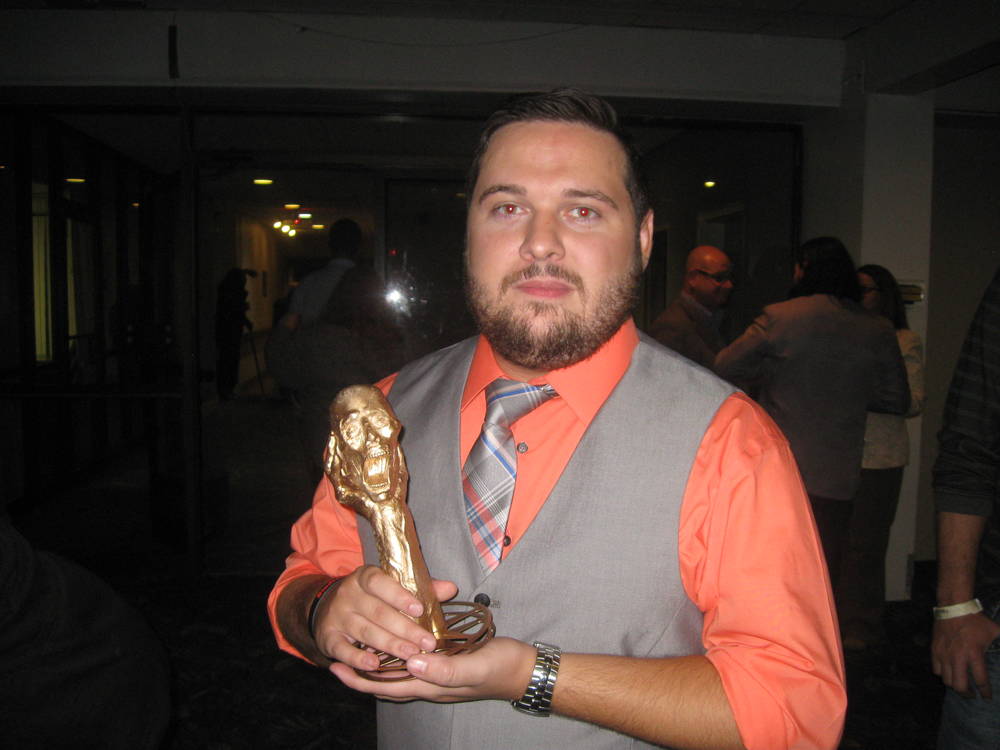 A proud and accomplished director grasping his award